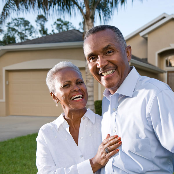 African American couple outside house in front yard