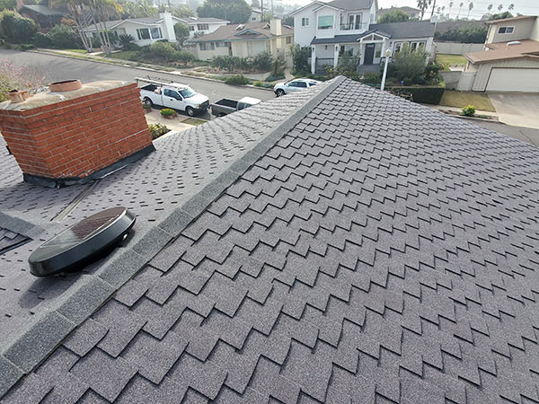 Grey rooftop with brick chimney.