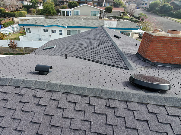 Grey rooftop with brick chimney.